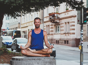 Auf diesem Bild ist Yogalehrer Fabian in Stuttgart. Er freut sich auf die nächste Yoga Stunde.