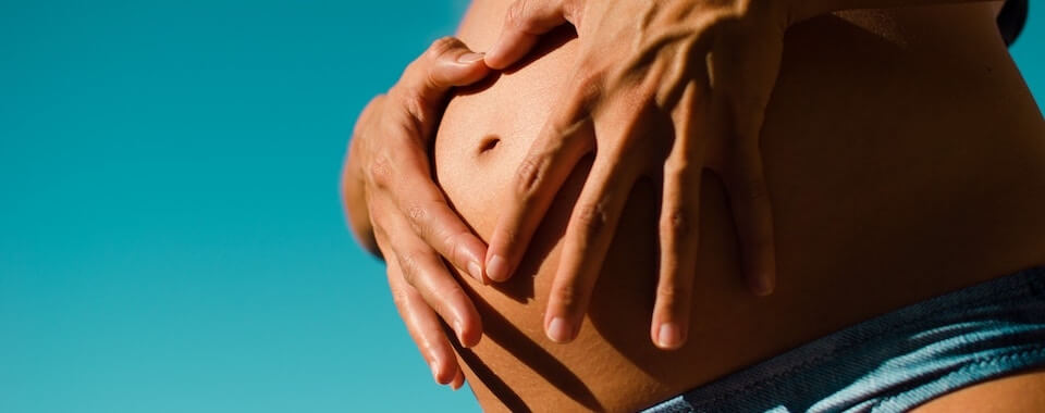 Yoga für Schwangere: Eine schwangere Frau die in der Sonne in Stuttgart West Yoga macht.