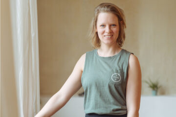 Yogalehrerin Christiane steht am Fenster des Yogastudios Fuß über Kopf in Stuttgart-West und lächselt freundlich in die Kamera