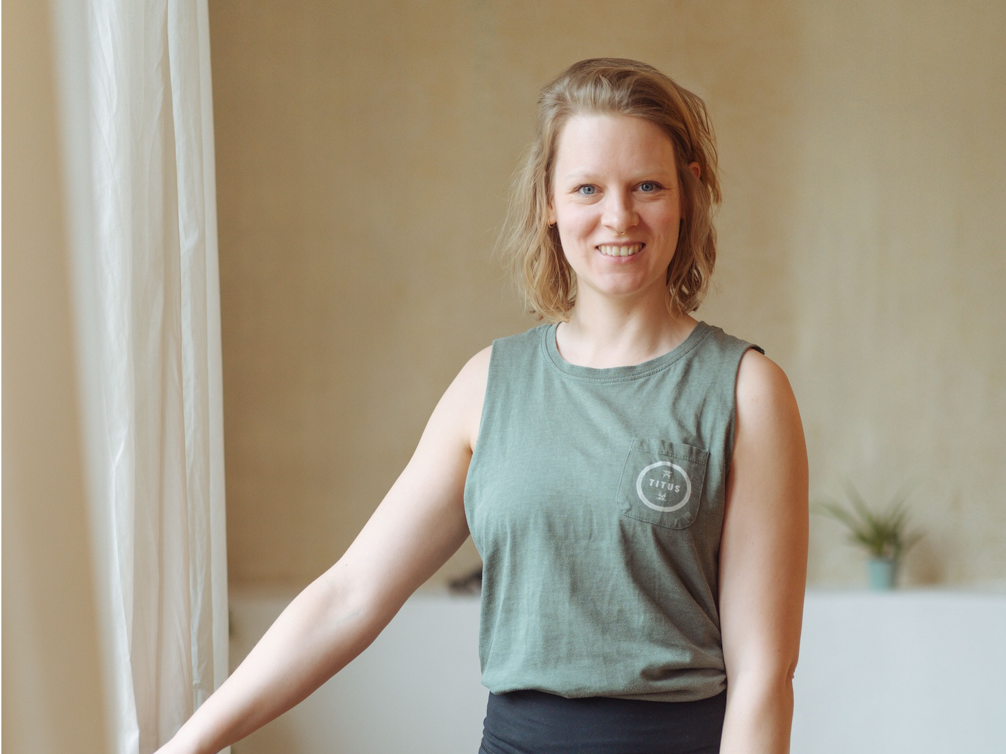 Yogalehrerin Christiane steht am Fenster des Yogastudios Fuß über Kopf in Stuttgart-West und lächselt freundlich in die Kamera