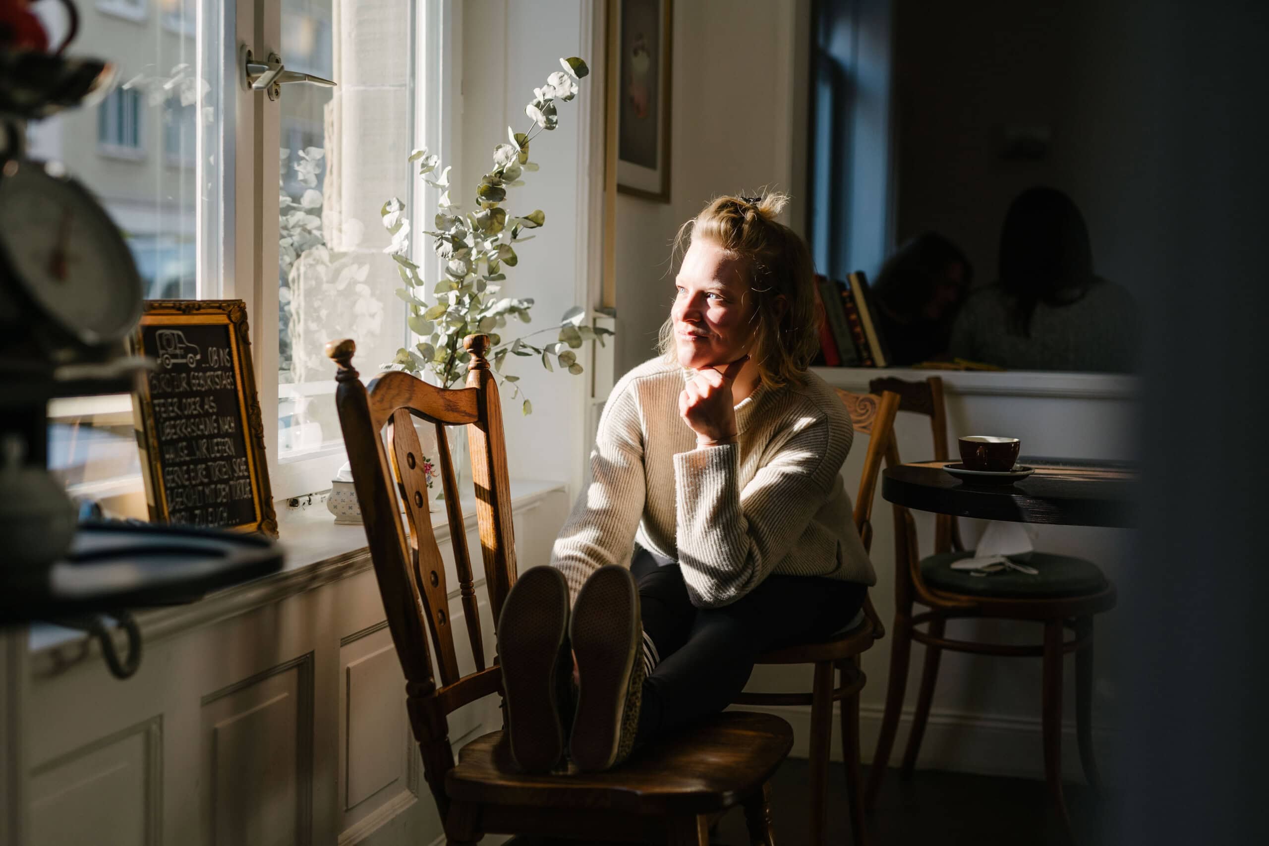 Yogalehrerin Christiane Havenith in einer Yoga-Haltung im Café in Stuttgart-West