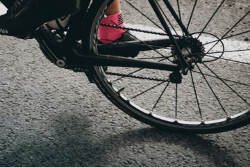 Das Hinterrad von einem Gravelbike und ein Fuß in Fahrradschuh und pinker Socke: Cycling, Cake und Yoga geht in die zweite Runde!