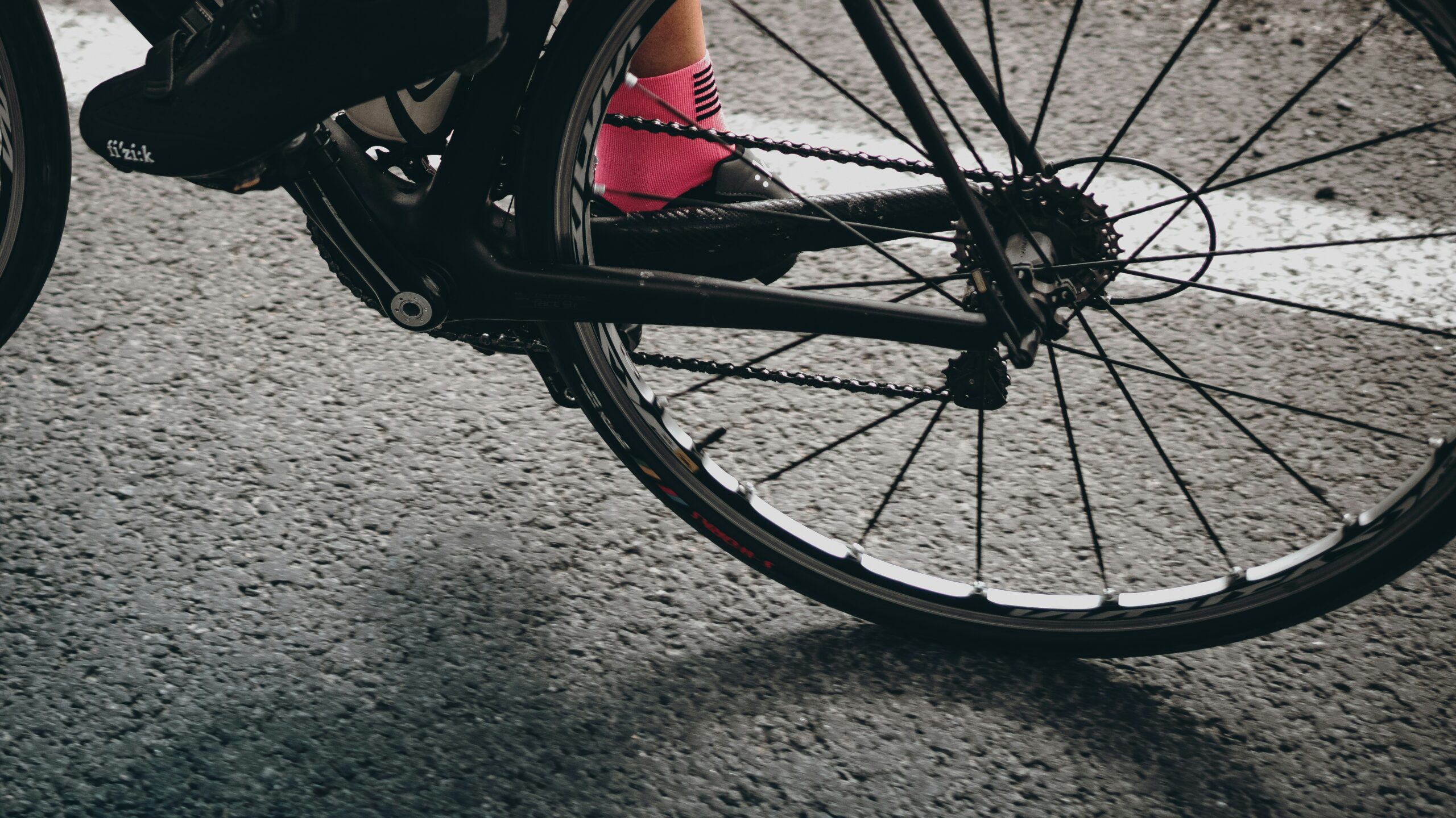 Das Hinterrad von einem Gravelbike und ein Fuß in Fahrradschuh und pinker Socke: Cycling, Cake und Yoga geht in die zweite Runde!