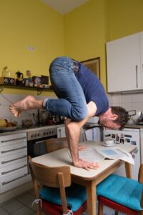 Yogalehrer Fabian Schläper in der Krähe auf einem Küchentisch